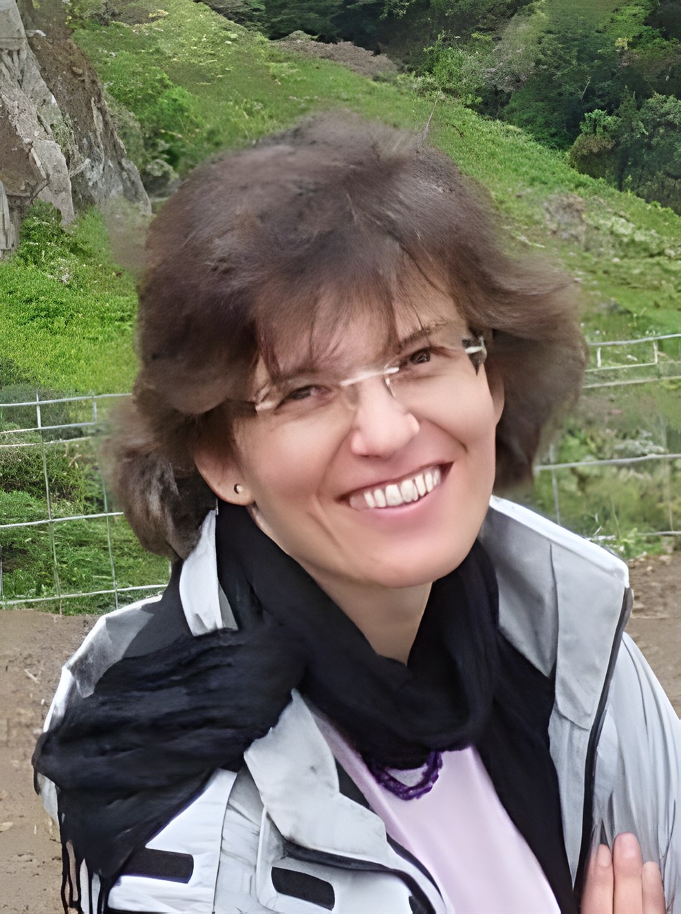 Ursula Scheid im Freien, vor einer grünen Hanglandschaft